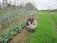 Steffanie Scott, a CFS Hub collaborator, crouches near some vegetables she is growing.