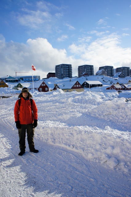 Standing by the harbor in Nuuk’s Old Town on a clear day.