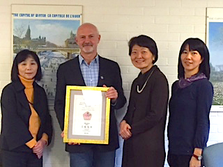 Dr David Wood, Ms. Iwanaga, Yoko Azuma, and Mami Sasaki holding certificate.