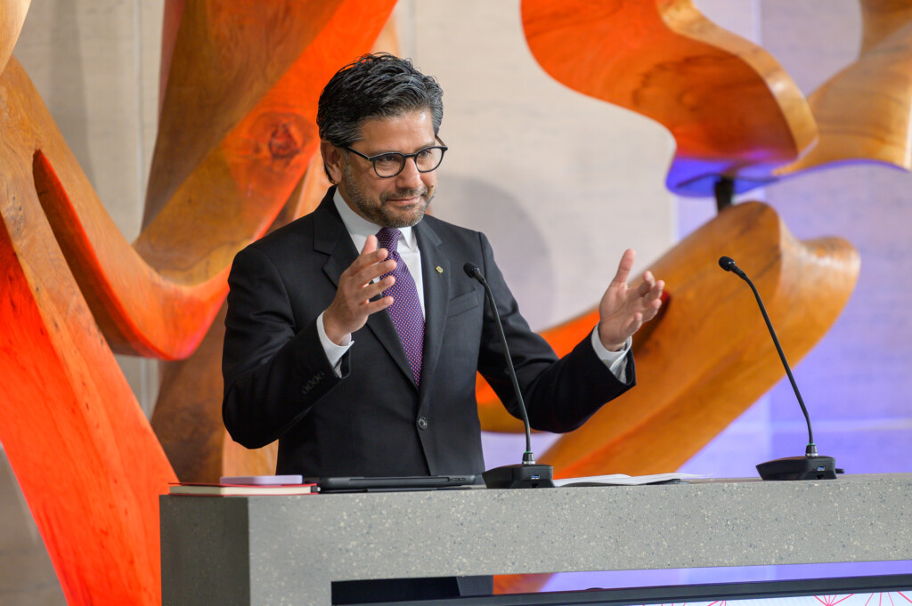 Yasir Naqvi speaking at the podium during opening session.