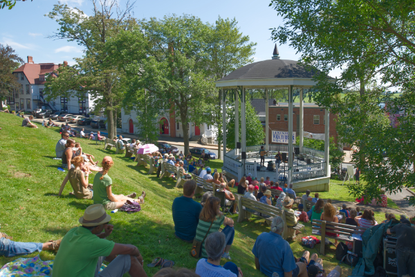People gather around a bandstand and listen to musicians playing in Lunenburg.