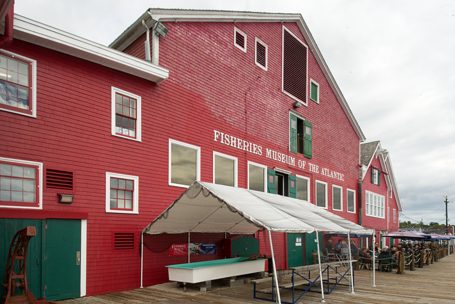 A bright red wooden building next to the wharf on Lunenburg Harbour.
