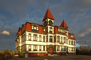 A large, ornately decorated, picturesque wooden building seen in dawn light.