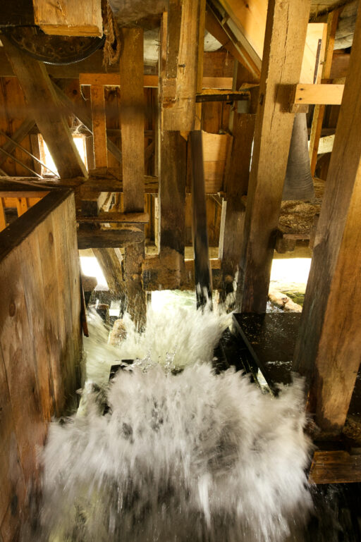 Churning, frothing whitewater moves among wooden and metal mechanisms.