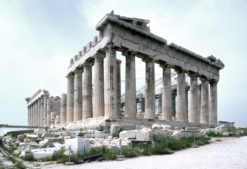 Photograph of a semi-ruined Doric temple of white marble, taken from a 3/4 angle.