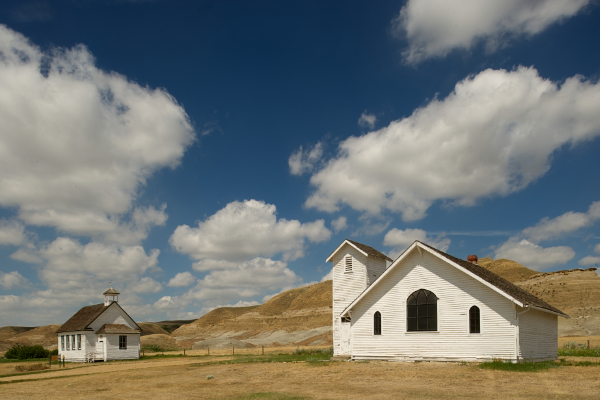 Old white, wooden churches in Badlands landscape.