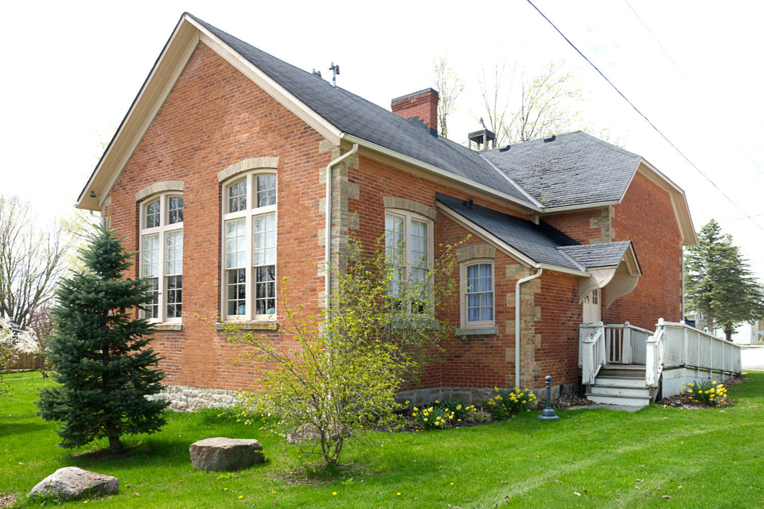 A handsome but smallish red brick building with large windows and some decorarive flourishes.