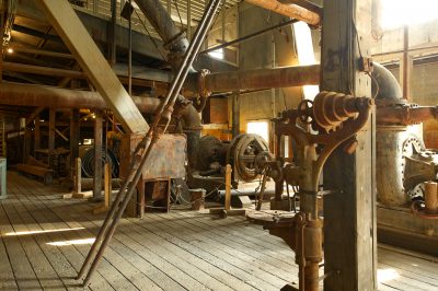 A large, abandoned and rusted industrial interior.