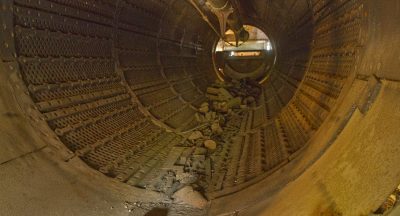 The interior of a massive, rusty metal cylinder.