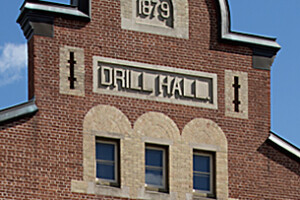 Detail of thriple windows nd gable of brick building.