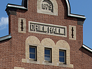Detail of thriple windows nd gable of brick building.