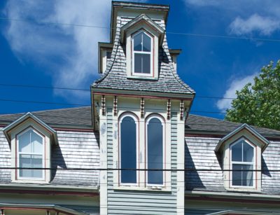 Detail of the front of an ornate Victorian wooden house.