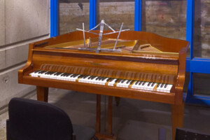 A piano in the corner of an institutional space.