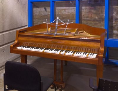 A piano in the corner of an institutional space.