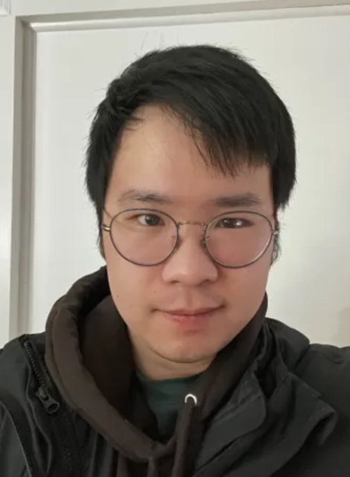 Staff headshot of Ken Yi Lei Le, facing the camera and wearing a dark grey hoodie and glasses.