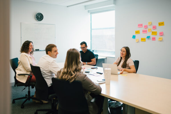 Five people collaborating at a boardroom table