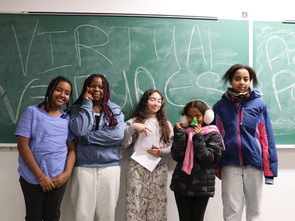 Virtual Ventures participants stand in front of a chalk board
