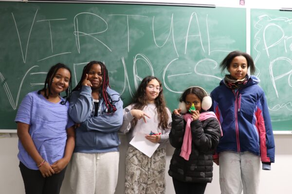 Virtual Ventures participants stand in front of a chalk board