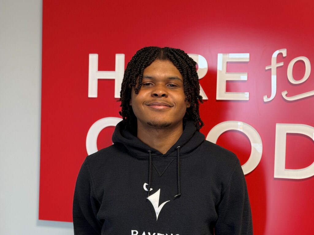 Daniel King smiles in a Ravens sweater