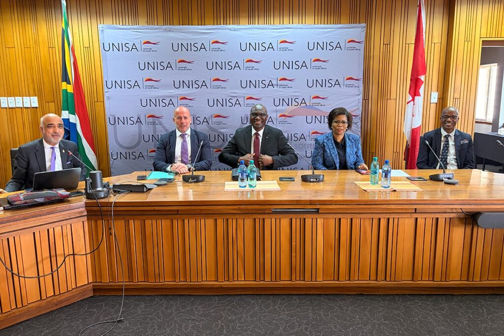 “Five participants seated at a conference table during a meeting at UNISA
