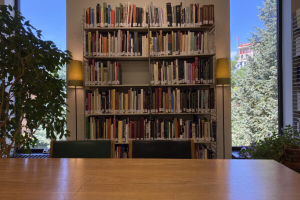 A photo of the AVRC showing a wooden table, bookshelves, two windows and two plants.