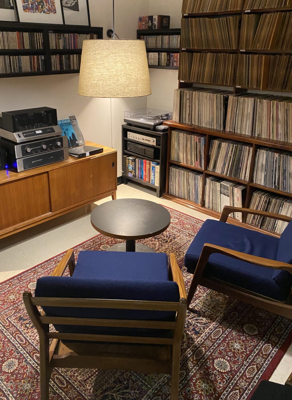 View of the Tolley room, showing two blue upholstered armchairs and a coffee table sitting on a carpet.
