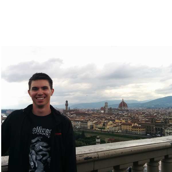A photo showing the author of the post, a young light-skinned man with black hair, posing in front of a view over a balcony.