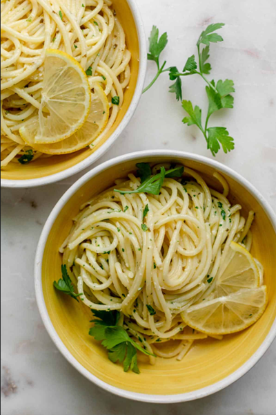 Overhead picture of 2 bowls of lemon pasta with cilantro sprinkled on top.