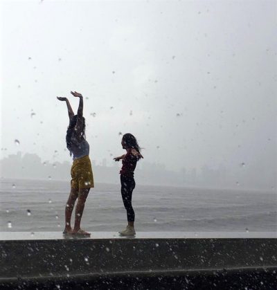 Image of Two children dancing in the Monsoon Rains in Mumbai India, photo taken by student on an International Placement