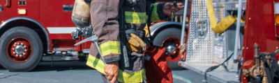 Detail of fire fighter standing next to fire truck