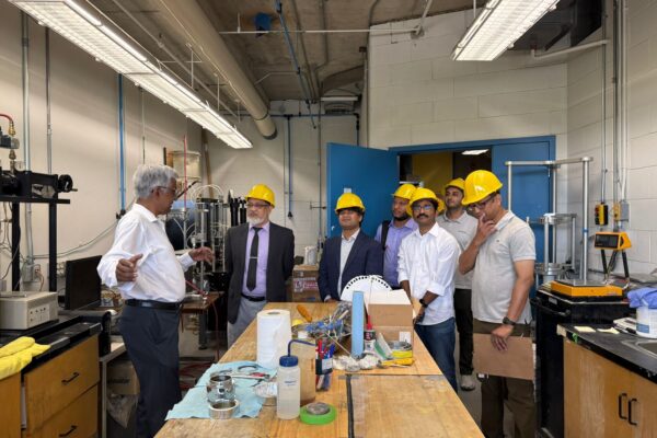 A group of faculty review a Geotechnical Lab with Prof. Siva Sivathayalan.