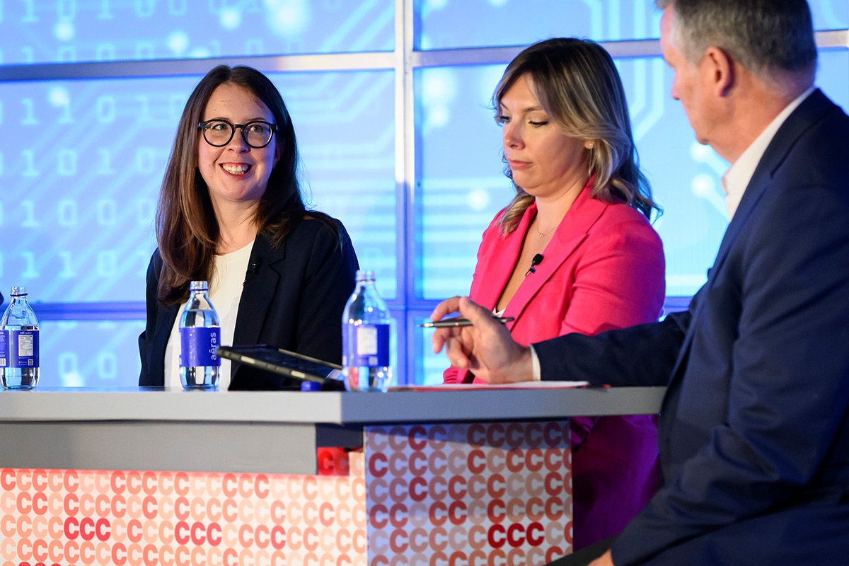 Three people having a conversation during a panel discussion.