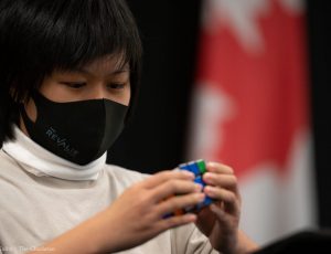 Photo of Andrea Chan, student competitor, solving the Rubik's Cube