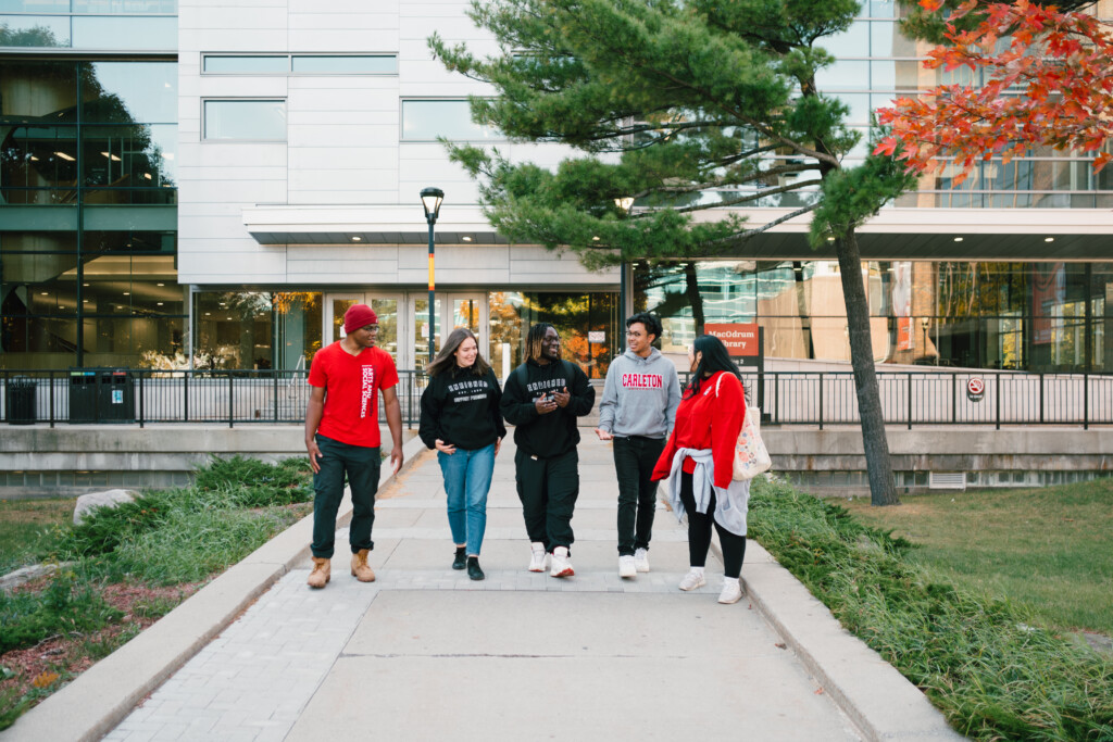 5 students walking through campus