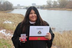 Jessica Rocheleau holding Carleton degree and medal in graduation gown