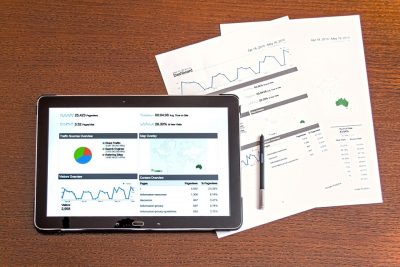 A tablet with a screen displaying different charts and graphs of analytics.