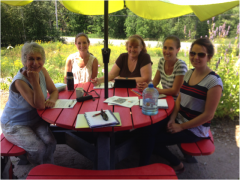 Sheila Ziman, Jenna Snelgrove, Marie Gage,Heather Reid and Cara Steele sitting outside at a picnic table discussing upcoming event