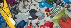 assortmnet of outdoor athletic gear: kayak, bicycle, backpacks, jackets