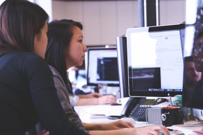 Profile shot of two women working together at a computer.