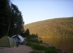 Campers enjoy a view of the mountain and lake from their tent. 