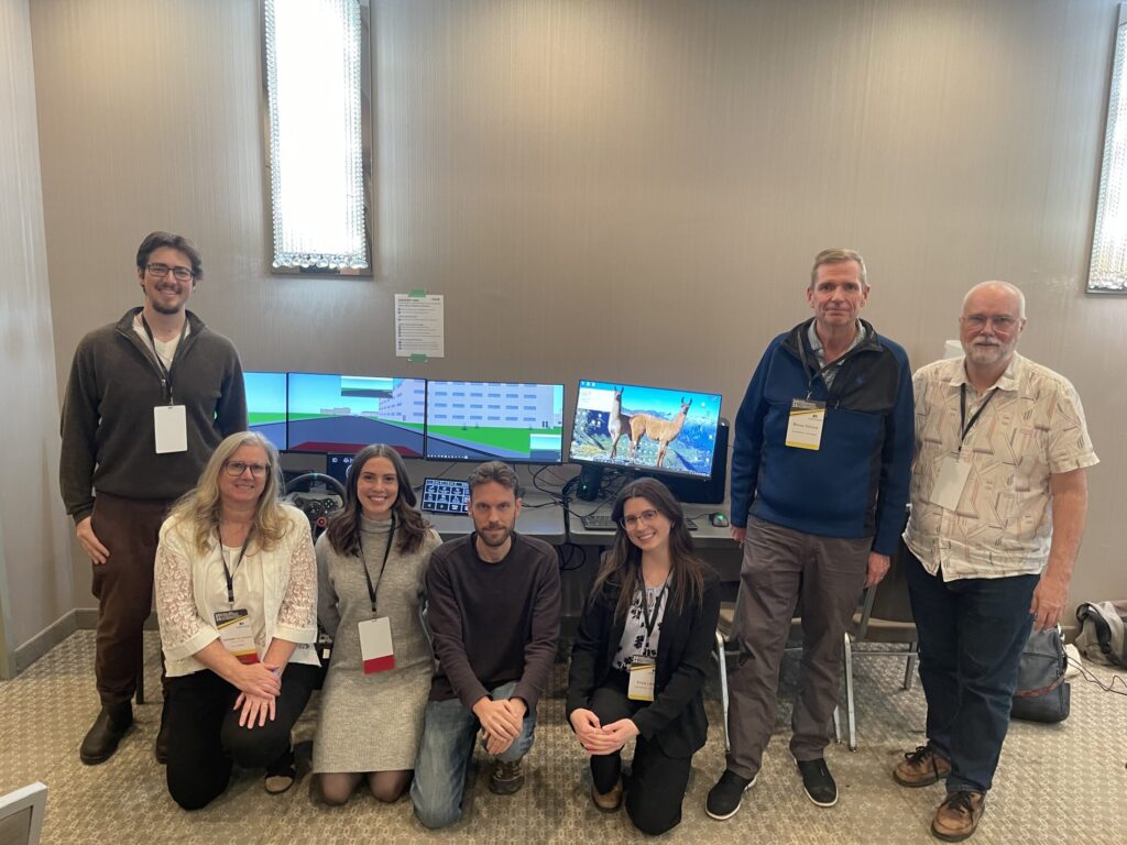 The CONNECT Project team and York Computer Technologies staff standing in front of a driving simulator.