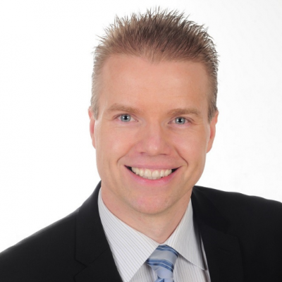 Headshot of Daniel Gulanowski. He is wearing a black suit with a white dress shirt and blue-striped tie.