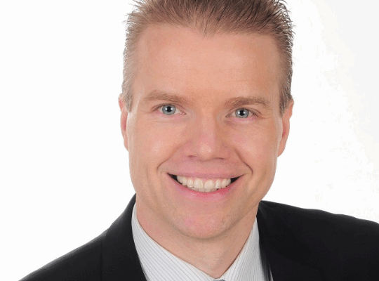 Headshot of Daniel Gulanowski. He is wearing a black suit with a white dress shirt and blue-striped tie.