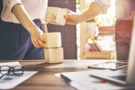 Two colleagues building with building blocks together