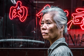 Close-up of Korean woman walking in front of storefront