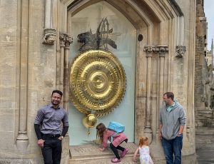 Alvi Jawad in front of the Corpus Clock and the time-eating insect in Cambridge, UK