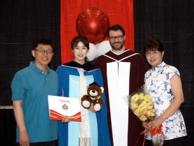 Xinrui Zhang celebrating the completion of her PhD at Convocation 2025 with her parents and thesis supervisor, Jason Jaskolka