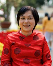 There is a portrait of a woman with short black hair who is wearing a red ao dai – the traditional costume of Vietnam.