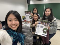 Four people take a selfie, with two holding a poster of the Decolonial Disability Studies Collective