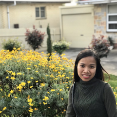 This is a photo of a woman with straight black hair and an emerald green turtleneck.